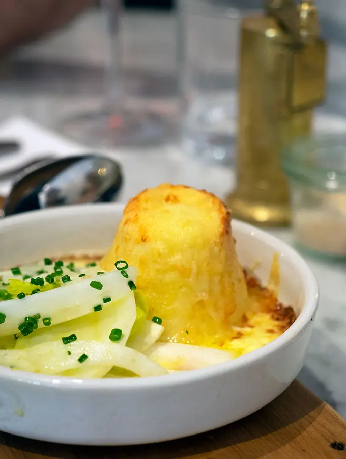 twice baked cheese souffle in a bowl with salad