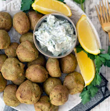 baked falafel on a plate with wedges of lemon