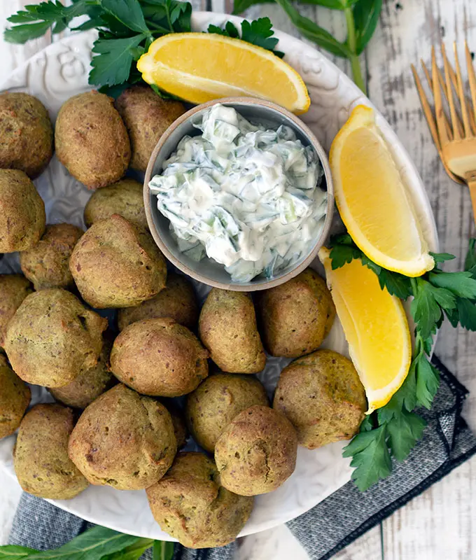 baked falafel on a plate with wedges of lemon