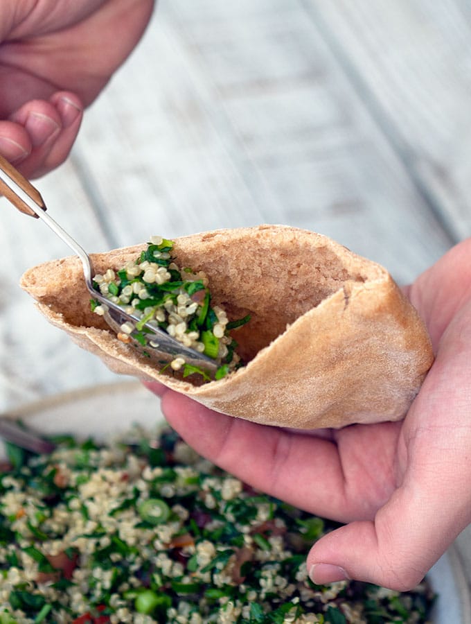 tabouli being spooned into a pita pocket
