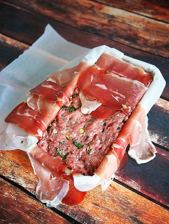 covering the top of the pork and veal terrine with prosciutto