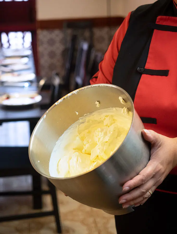 Chef Anna Manhao showing a mixing bowl where cream and condensed milk are being combined