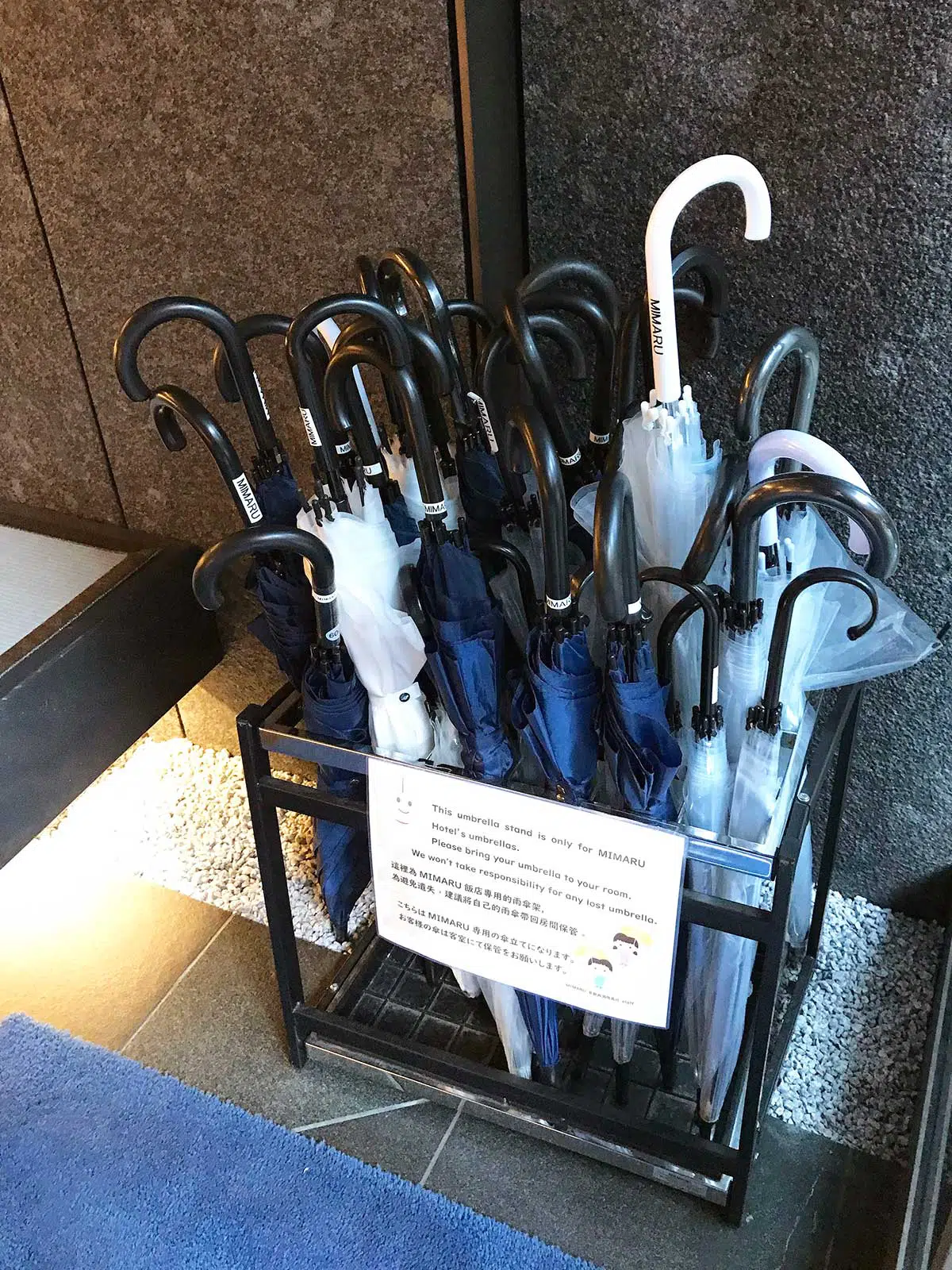 umbrellas in a stand at the door of the hotel for guests