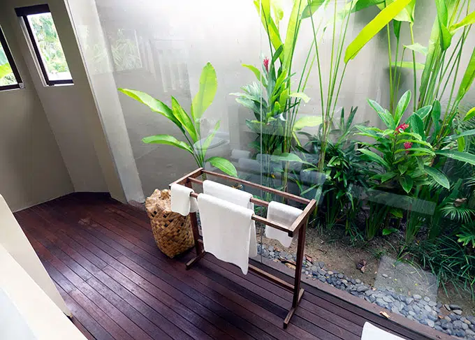 towel rack in cabin bathroom with garden behind