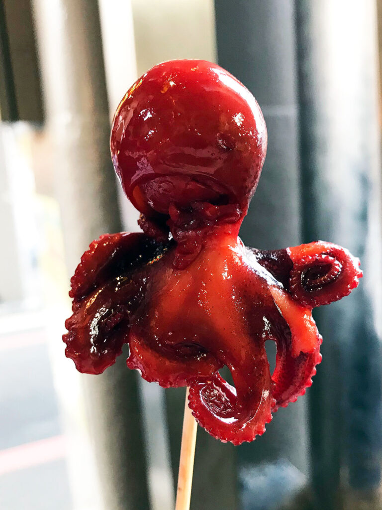 cooked baby octopus on a skewer with a quail egg in its head