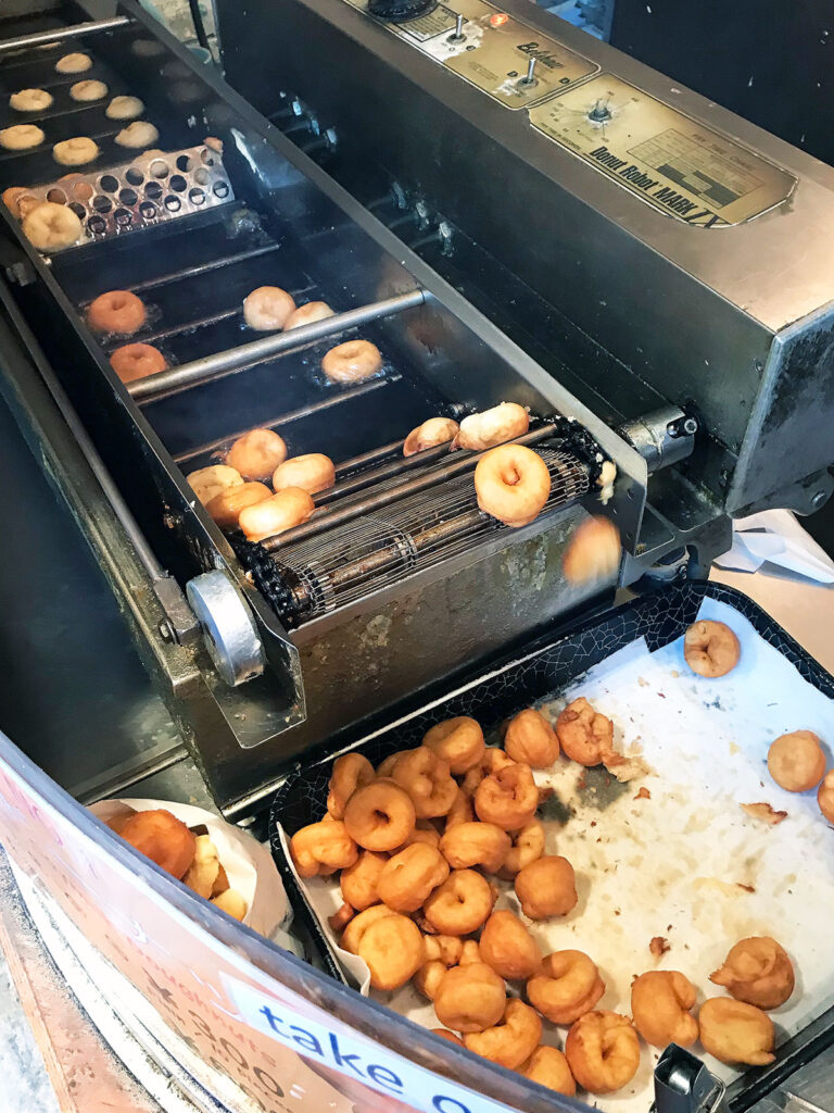 tofu donuts being cooked in a donut machine