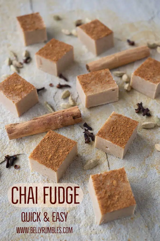 squares of chai fudge on a sandstone tile surrounded by dry spices