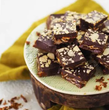 Almond Roca cut into squares on a green plate