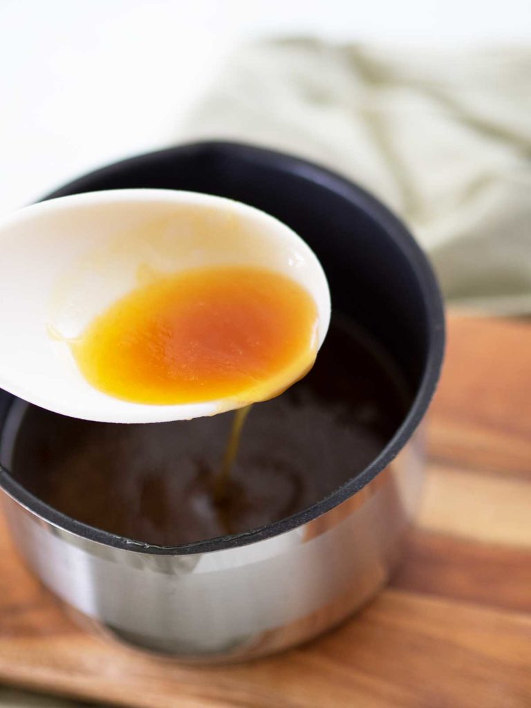 spoon showing sugar syrup mixture from saucepan