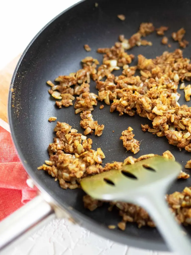 spices being cooked out in a fry pan for the curry