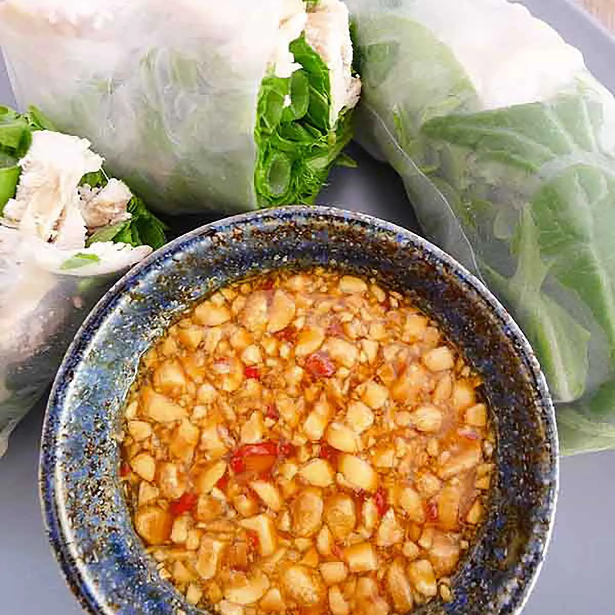 peanut passion fruit dipping sauce in a bowl next to vietnamese fresh spring rolls