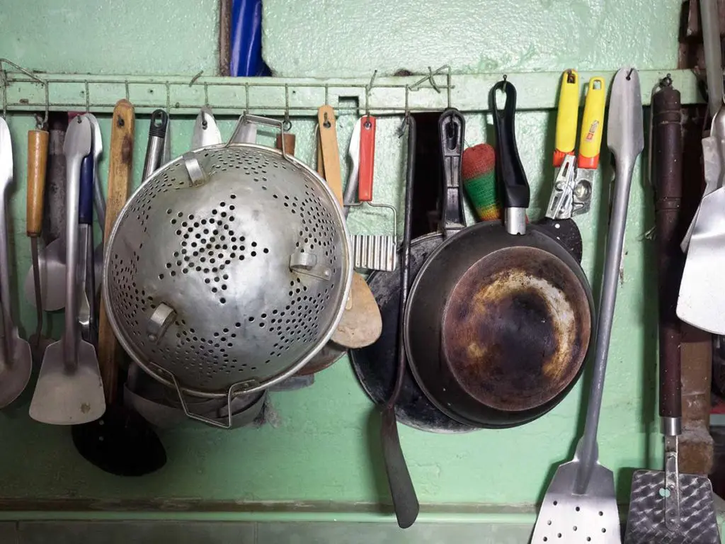 hanging kitchen utensils against a green pained wall