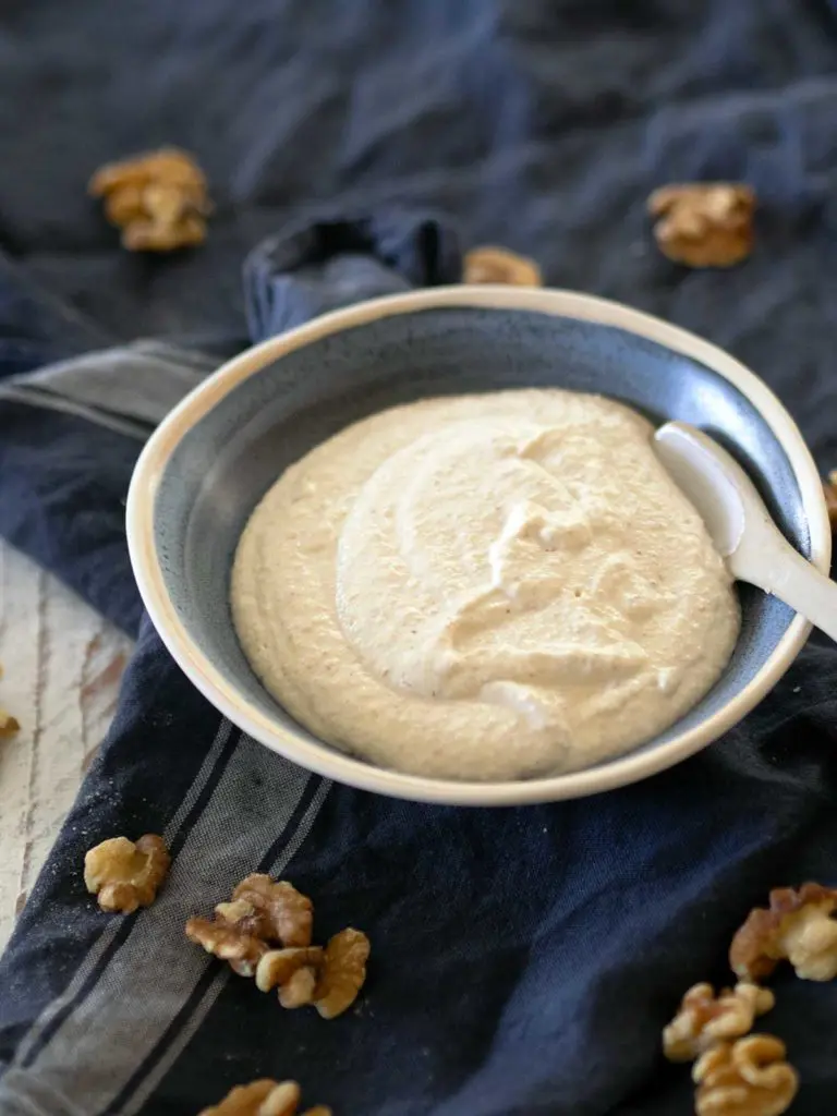 walnut sauce in a blue bowl with a spoon