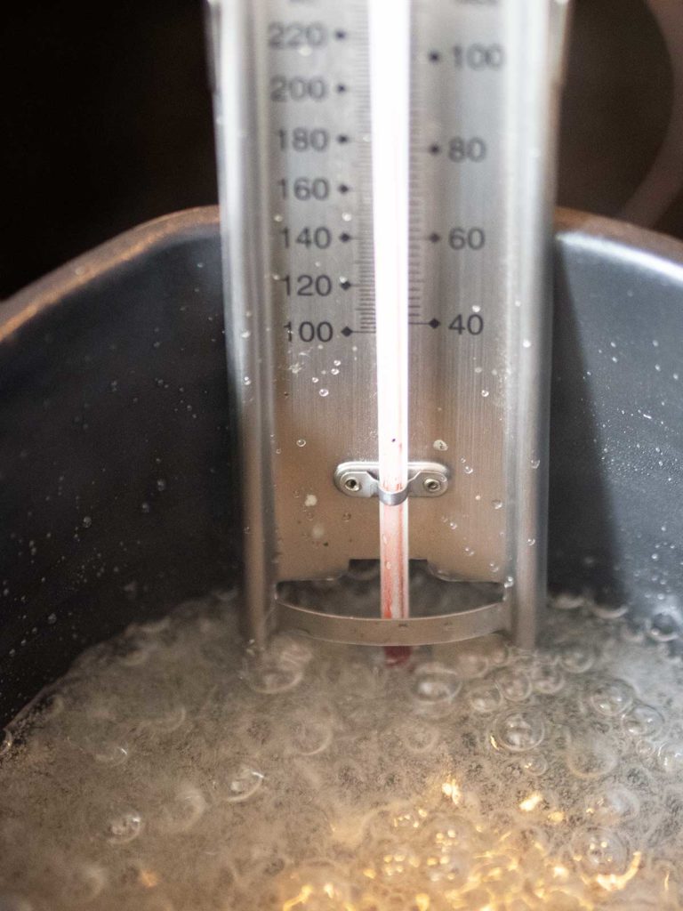 candy thermometer in a pot of boiling sugar