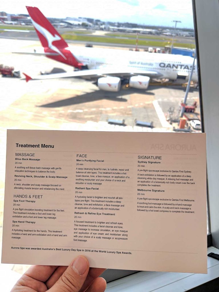 picture of the qantas spa menu taken in front of a window with a plane in the background
