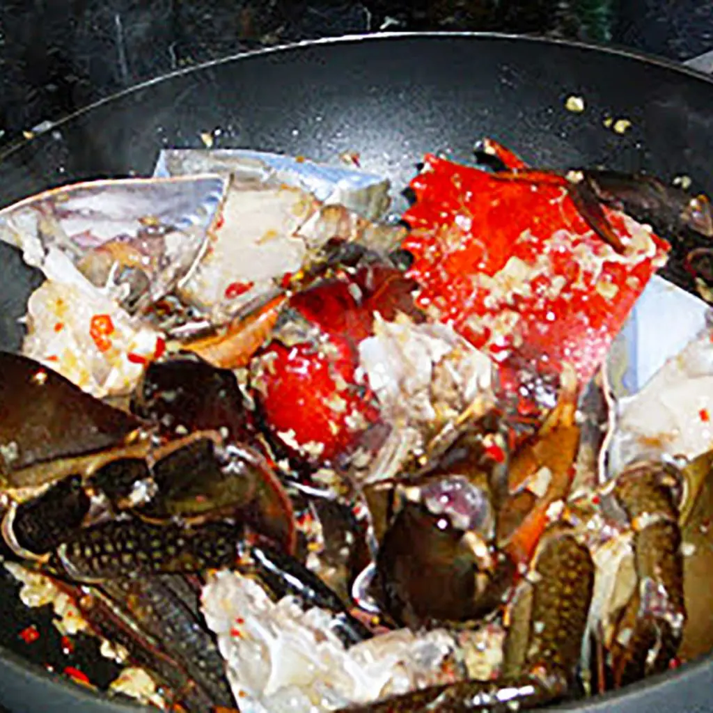 chilli mud crab being tossed in a wok