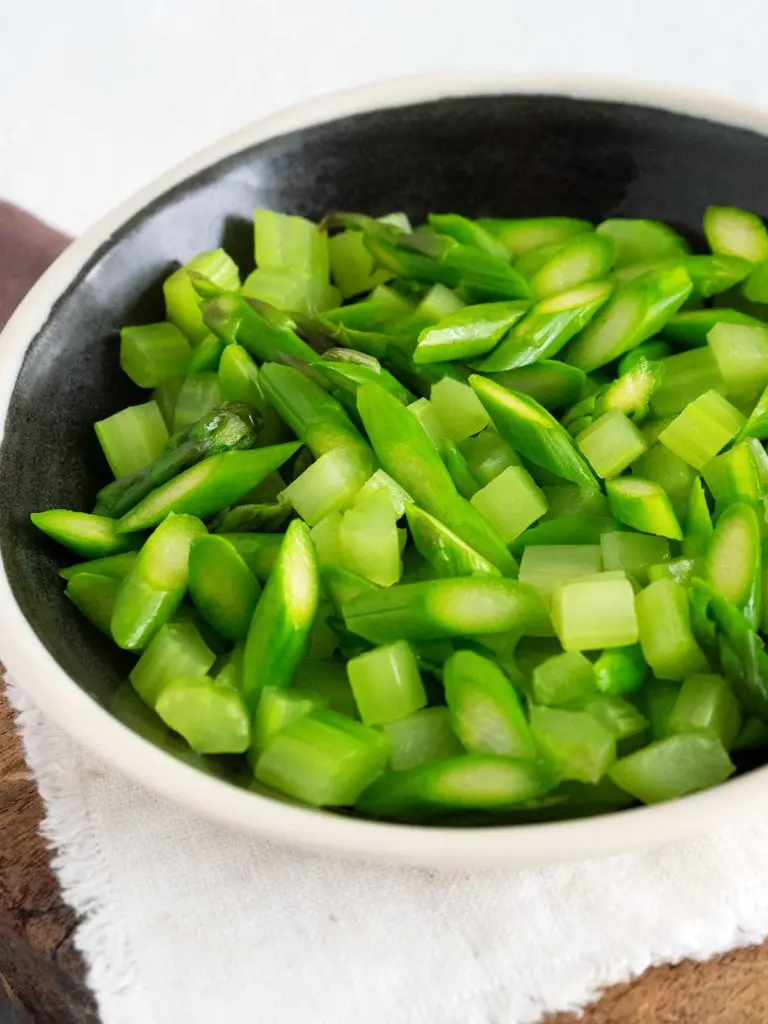 blanched asparagus and celery in a black bowl