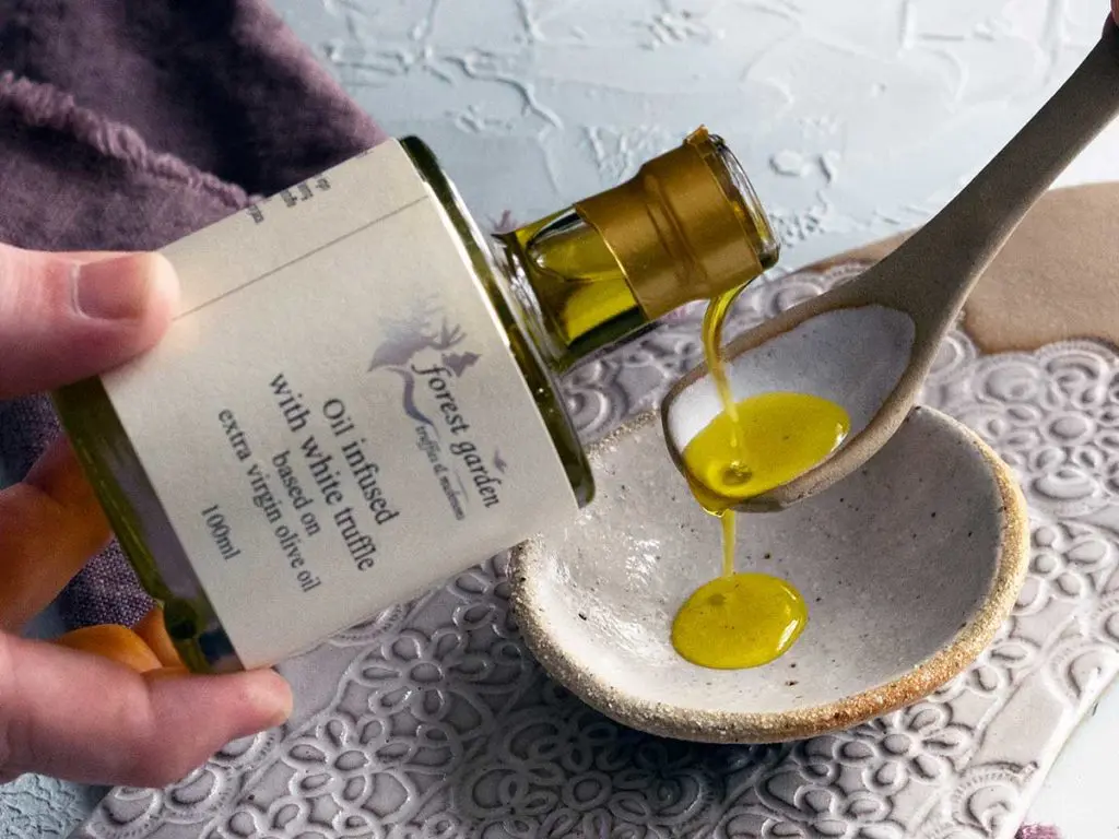 grecian purveyor white truffle oil being poured on to a ceramic spoon