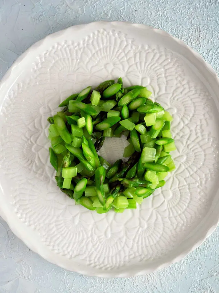 a ring of blanched diced asparagus and celery on a white plate