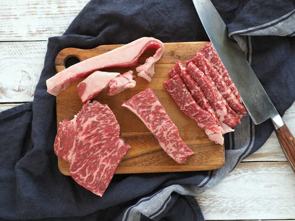 wagyu sirloin steak sliced and fat removed on a wooden board