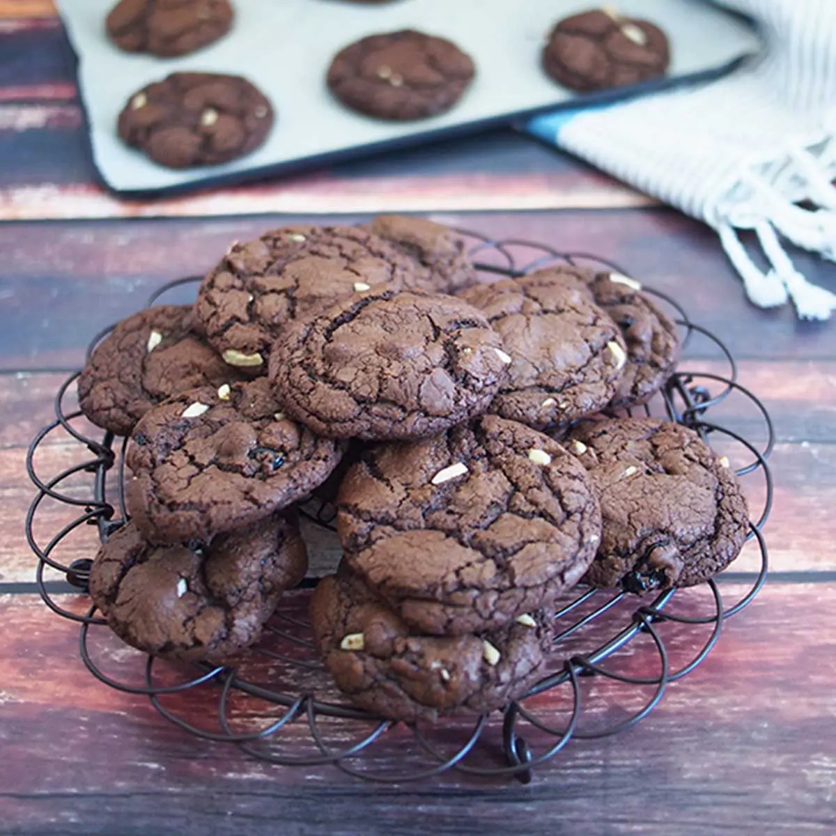 dark chocolate coockies resting on a black rack, dark wood background