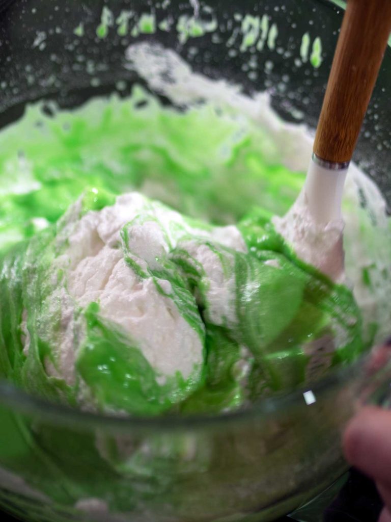 one third of egg whites being folded into pandan cake batter