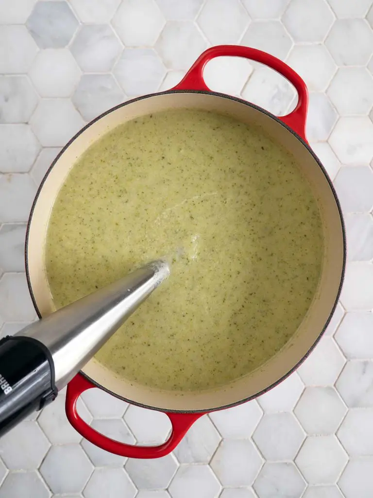 Soup being blended in the cooking pot with a stick blender.