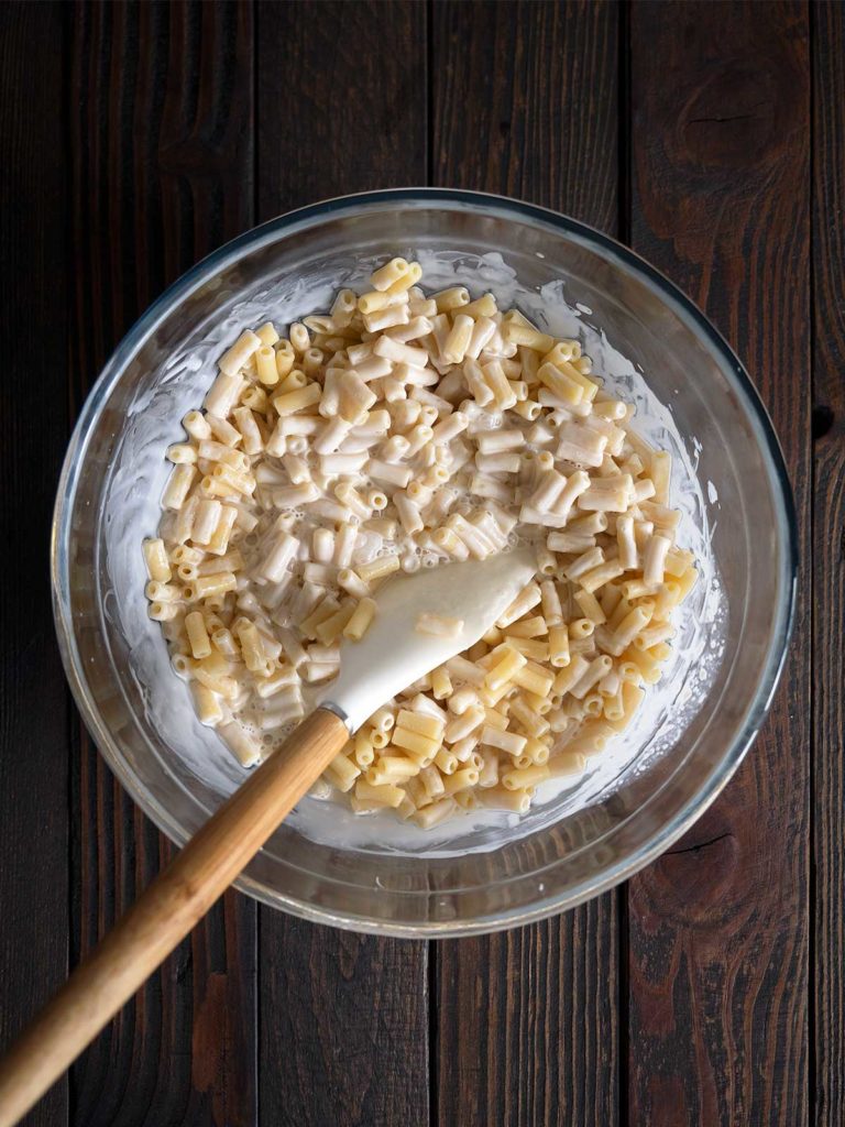 cream mixture being mixed into macaroni