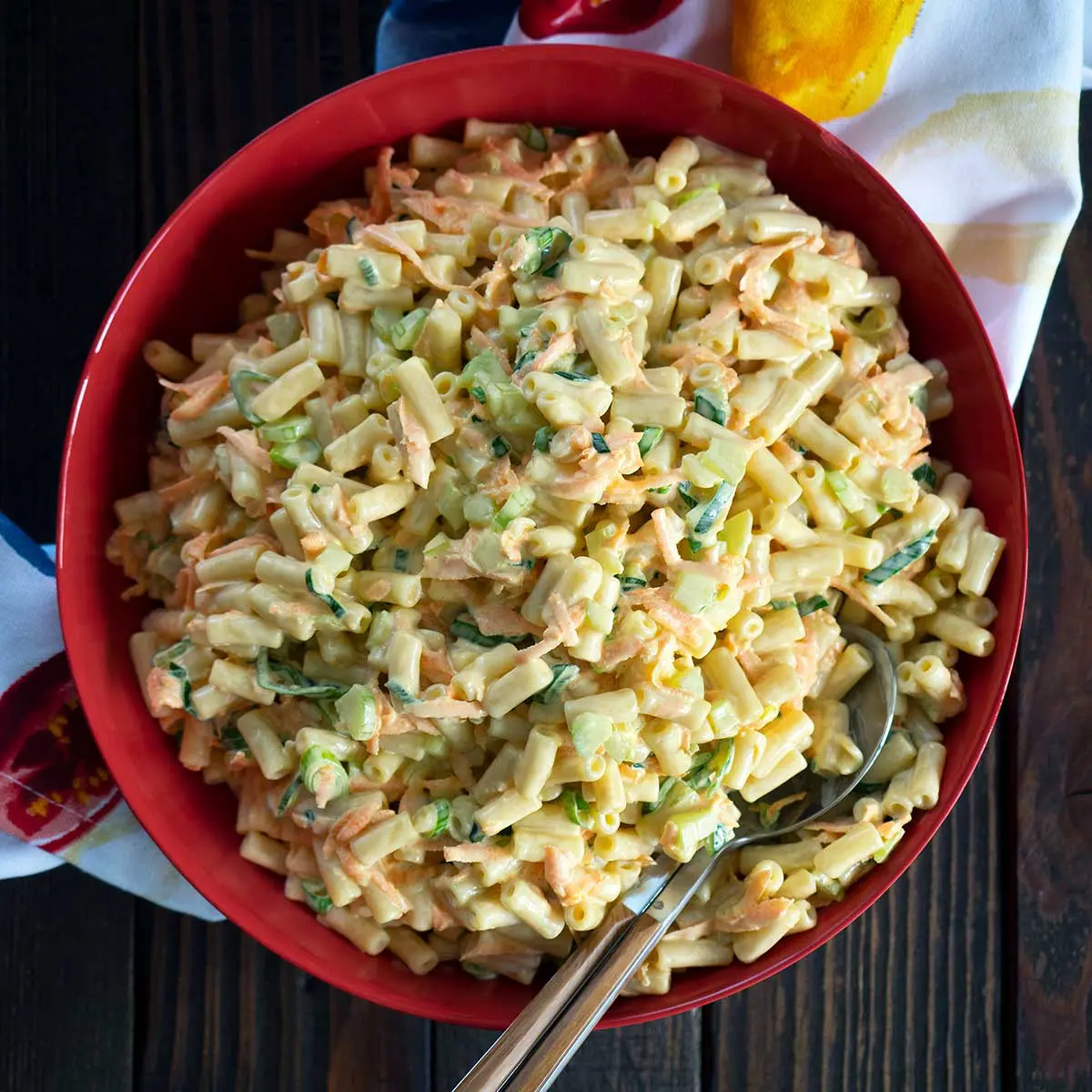 hawaiian salad in a red bowl with serving spoons
