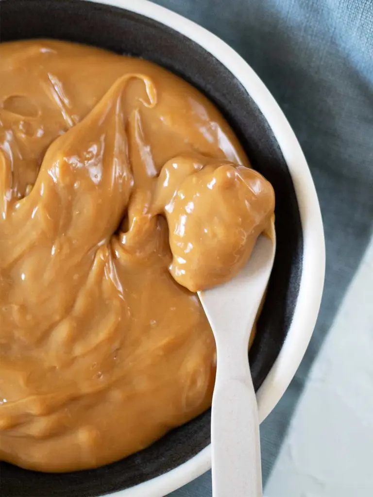 dulce de leche in a bowl with a spoon