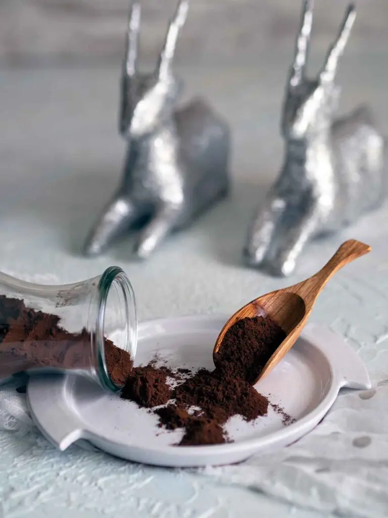 chocolate spice mix on a plate with spoon and toppled out of glass container