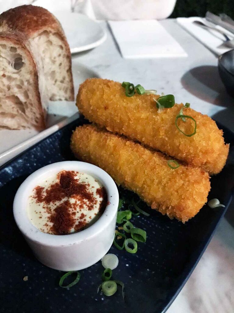 croquettes on a plate with dipping sauce