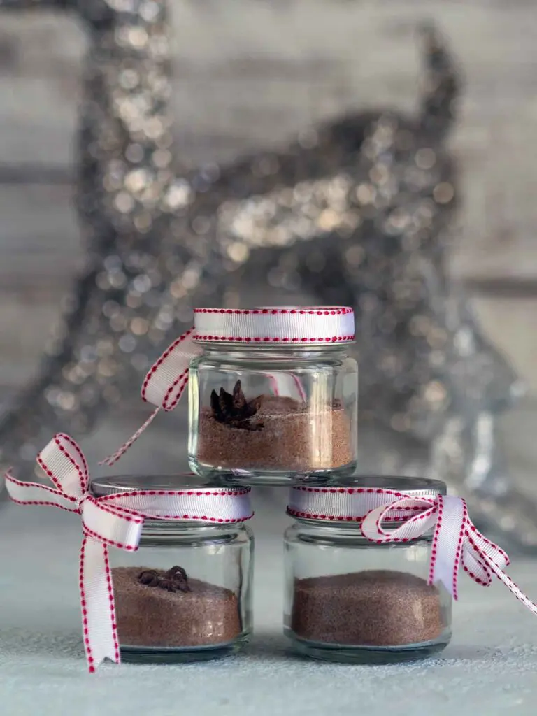 Jars of Christmas sugar stacked on top of each other with ribbon.