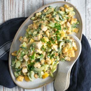 curry mango turkey salad on a serving platter with serving spoons