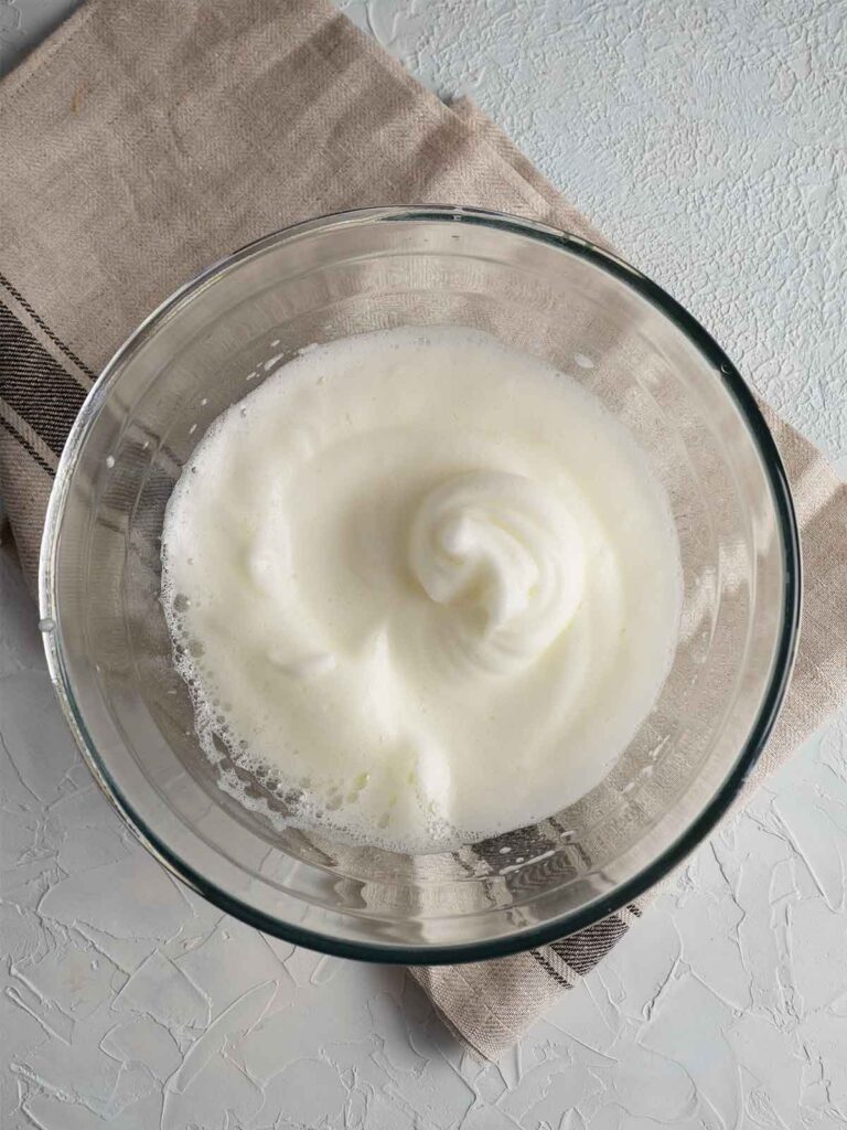 whipped egg whites in a glass bowl