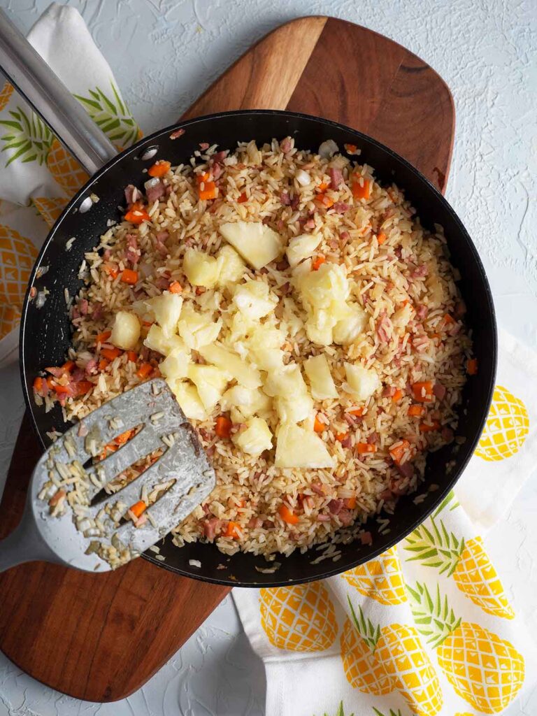 adding pineapple to the fry pan