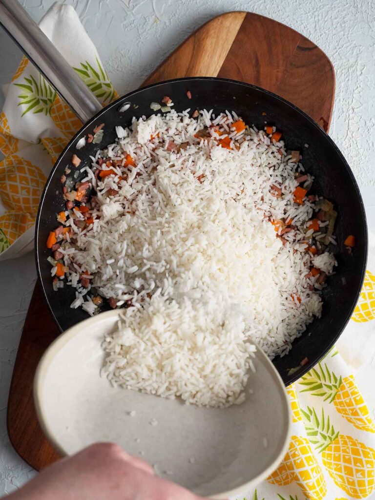adding rice to the fry pan