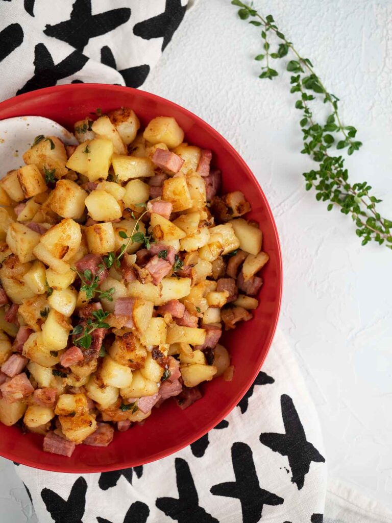 ham has in a red serving bowl on a piece of material with crosses