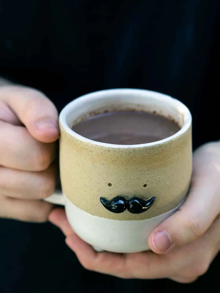 hot chocolate in a mr moustache mug being held