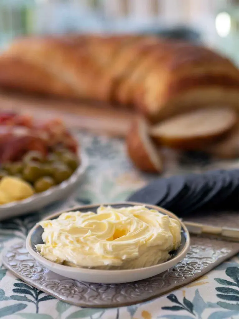 smoked butter on a table in a dish with bread and charcoal crackers