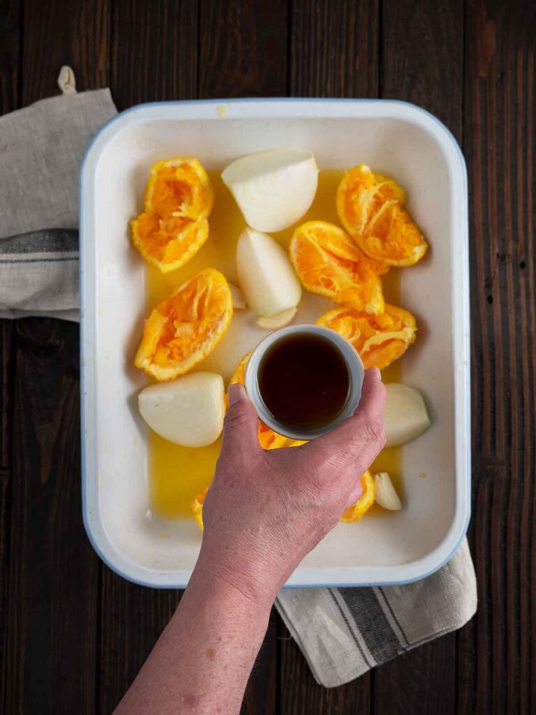 maple syrup being added to roasting pan