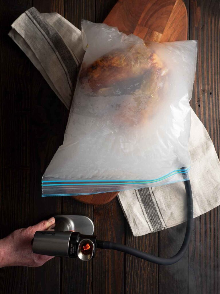 smoking gun adding smoke to the zip lock bag that holds the turkey