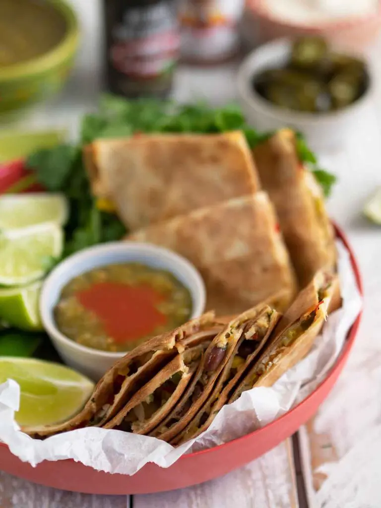 turkey quesadillas in a dish with sauce and lime