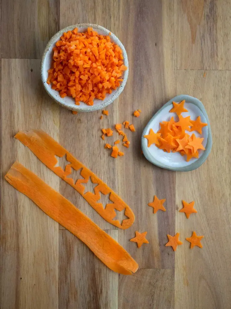 finely diced carrot and stars cut from thin carrot strips in bowls on a wooden board