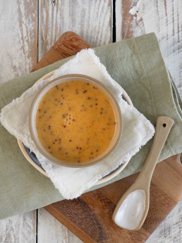 dressing in a bowl on a board with a spoon
