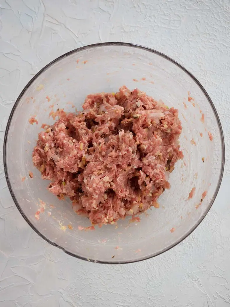 all the ingredients for the dumpling filling mixed in a glass bowl