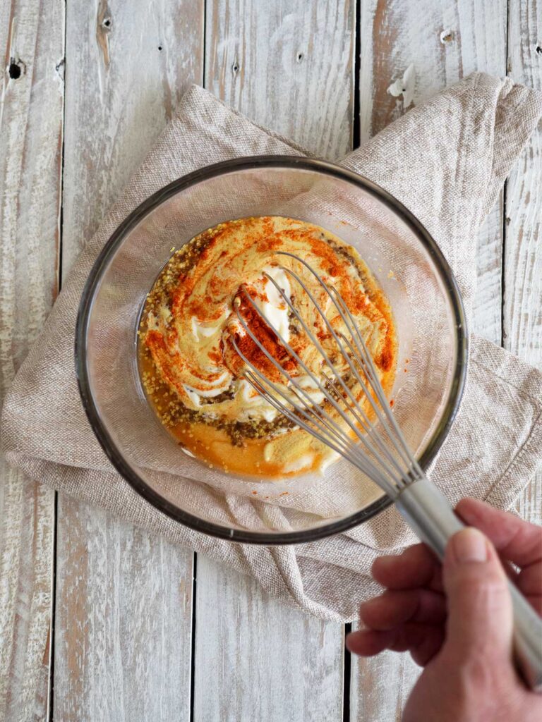 whisking ingredients in a glass bowl