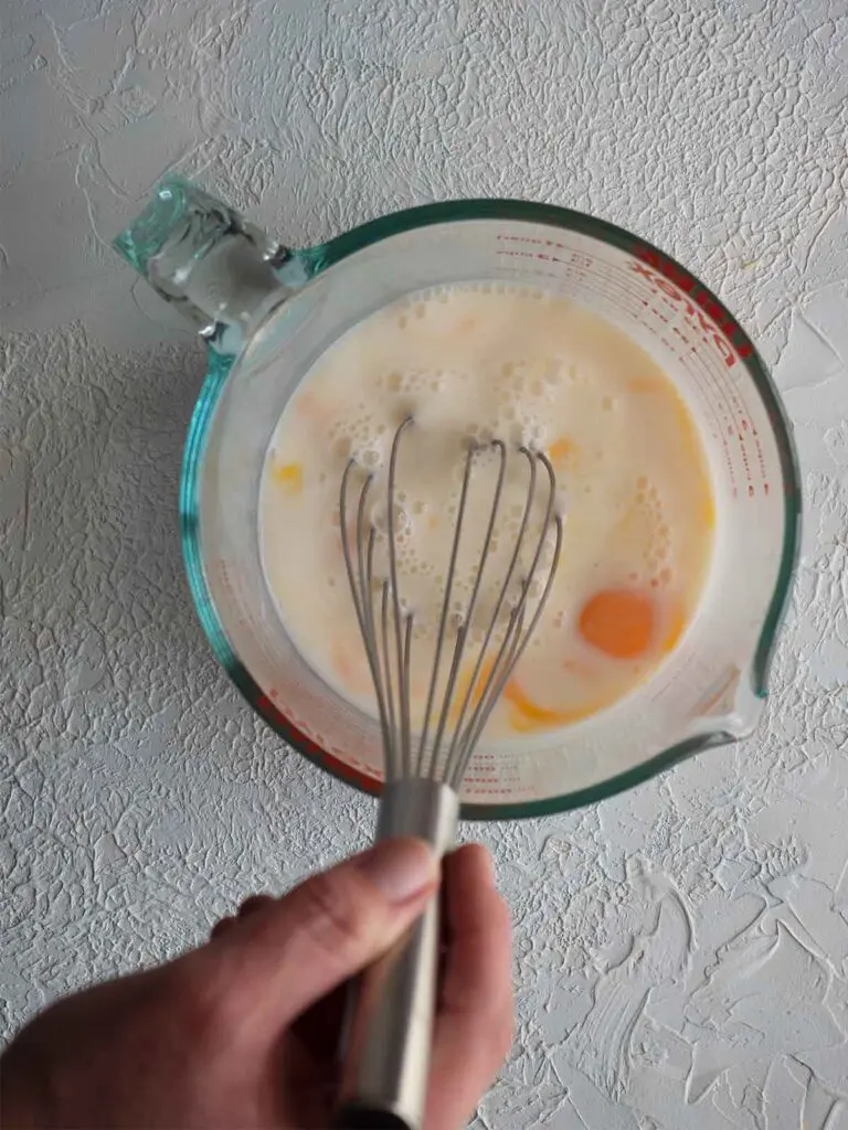 eggs and milk being whisked in a jug