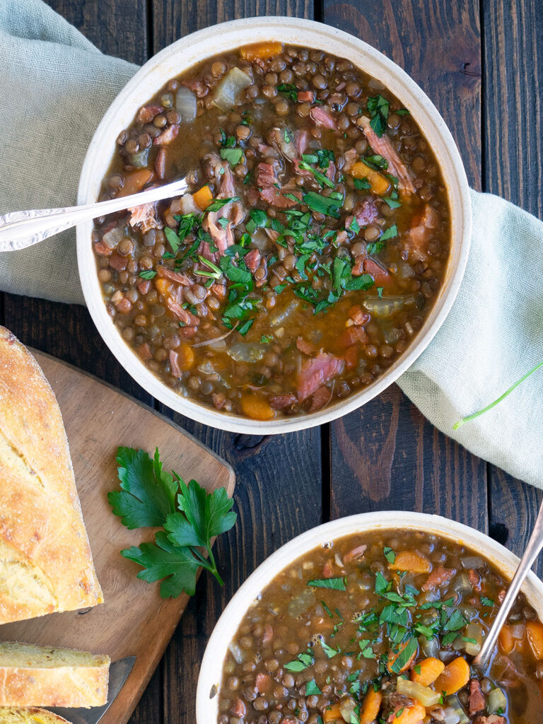 ham and lentil soup in bowls with spoons