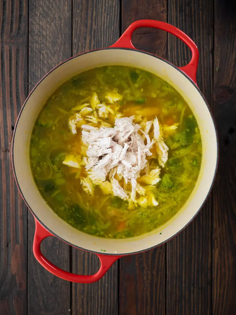 poached chicken is added to the ingredients in the dutch  oven